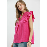 Model turned to the side in fuchsia textured ruffle sleeve top showing silhouette and material detail.