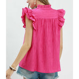 Model showing rear view of fuchsia textured top with ruffle sleeves.