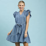 Model wearing the Chambray Ruffle Babydoll Dress, showing the ruffle sleeves, chambray texture, and flowy babydoll silhouette.