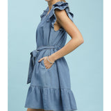 Side view of model wearing the Chambray Ruffle Babydoll Dress highlighting the ruffle sleeves and pockets.