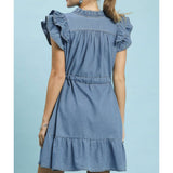 Model in chambray ruffle babydoll dress from behind highlighting the lightweight denim texture.