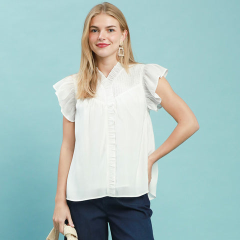 Model wearing an off‑white smocked yoke ruffle sleeve blouse, front view showing the smocked detail and soft ruffled sleeves.