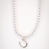 White Gold Pearl necklace with small angled horseshoe charm. 