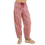 Close‑up of the red and white striped pants on a model, focusing on the vertical stripe pattern and soft woven texture.