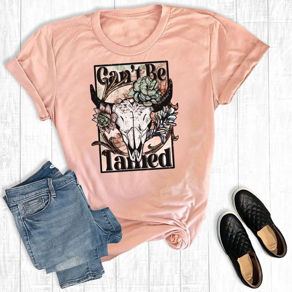 Peach Can’t Be Tamed Tee with cow skull and floral graphic on soft cotton-poly blend fabric