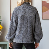 Woman wearing a gray cable knit sweater