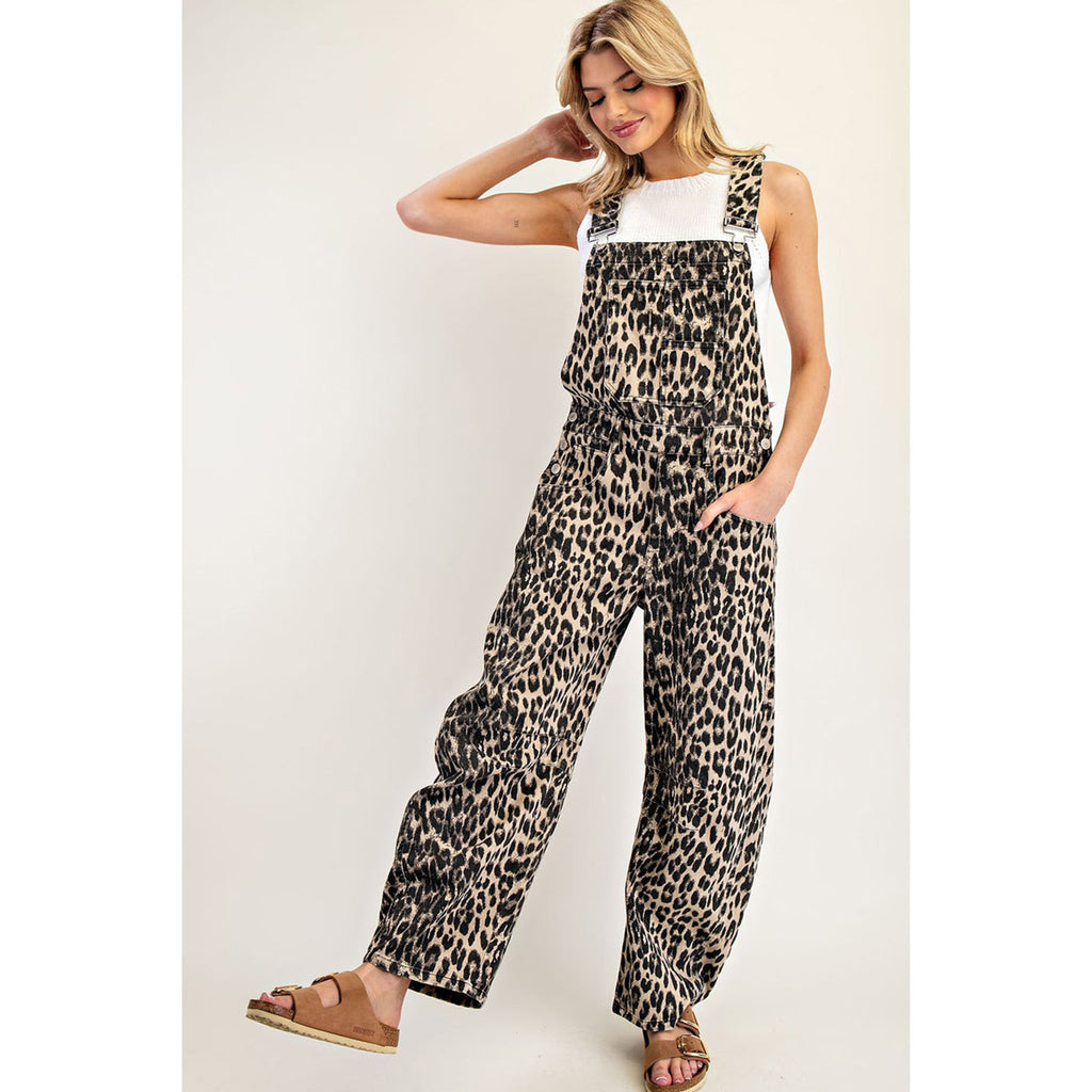 Woman wearing the Leopard Barrel Leg Jumpsuit, front view with one leg kicked out to show the wide barrel‑leg silhouette and bold leopard print.
