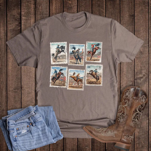 Flat lay of brown stamps t-shirt with boots and jeans laying around it. 