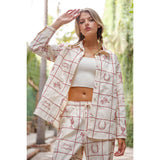 Model wearing a red grid Western button front shirt with embroidered details and a relaxed silhouette.