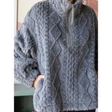 Close up of a woman wearing a textured gray fleece sweater