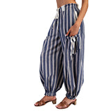 Model walking in navy and gray striped pants, showcasing the side pockets.