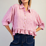 Front of the shirt, it is a rink and white striped collared button down that is cropped, has 3/4 length sleeves, ruffles at the bottom, and one chest pocket.