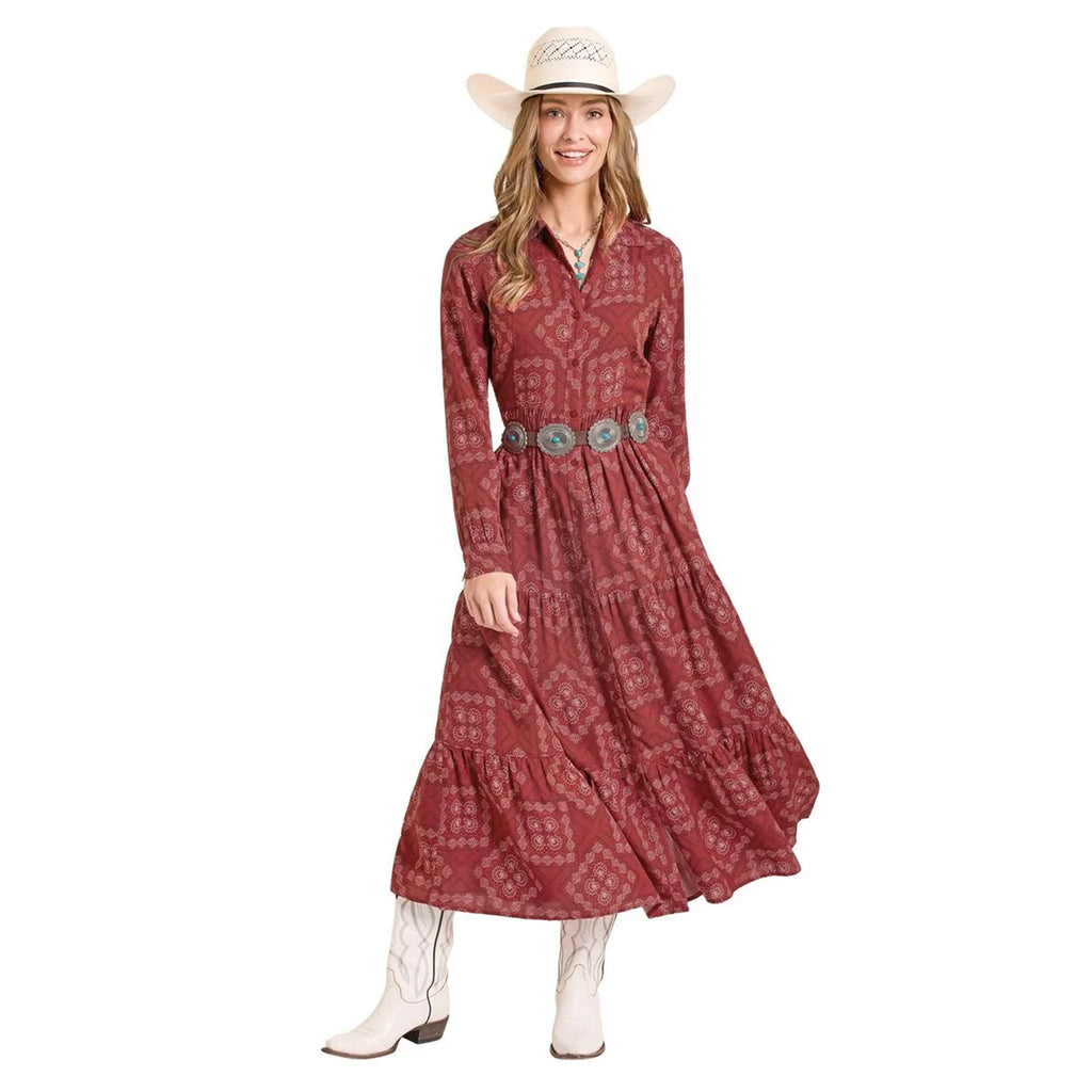 Model wearing a scarlet bandana‑print dress with a fitted bodice and flowy skirt, standing facing forward to show full silhouette.