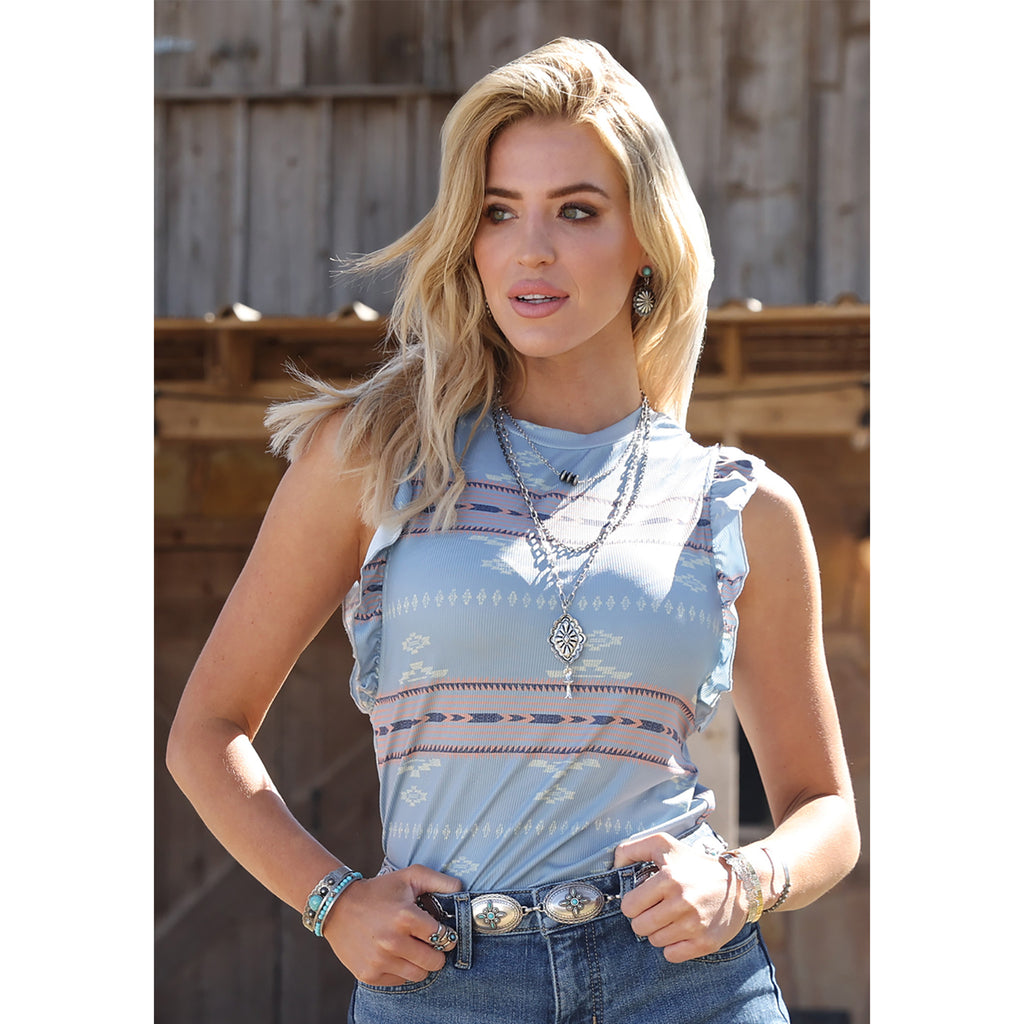 Woman wearing the Blue Aztec Ribbed Ruffle Tank, front view showing the bold blue Aztec print, ribbed texture, and soft ruffle trim