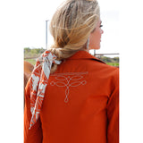 Back of women's rust pearl snap with white boot stitching on the back.