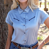 Model wearing light blue satin shirt tucked into jeans and front facing. 