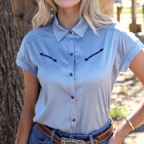 Model wearing light blue satin shirt tucked into jeans and front facing. 