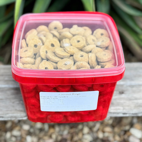Red container filled with coconut ring horse treats on a wooden surface