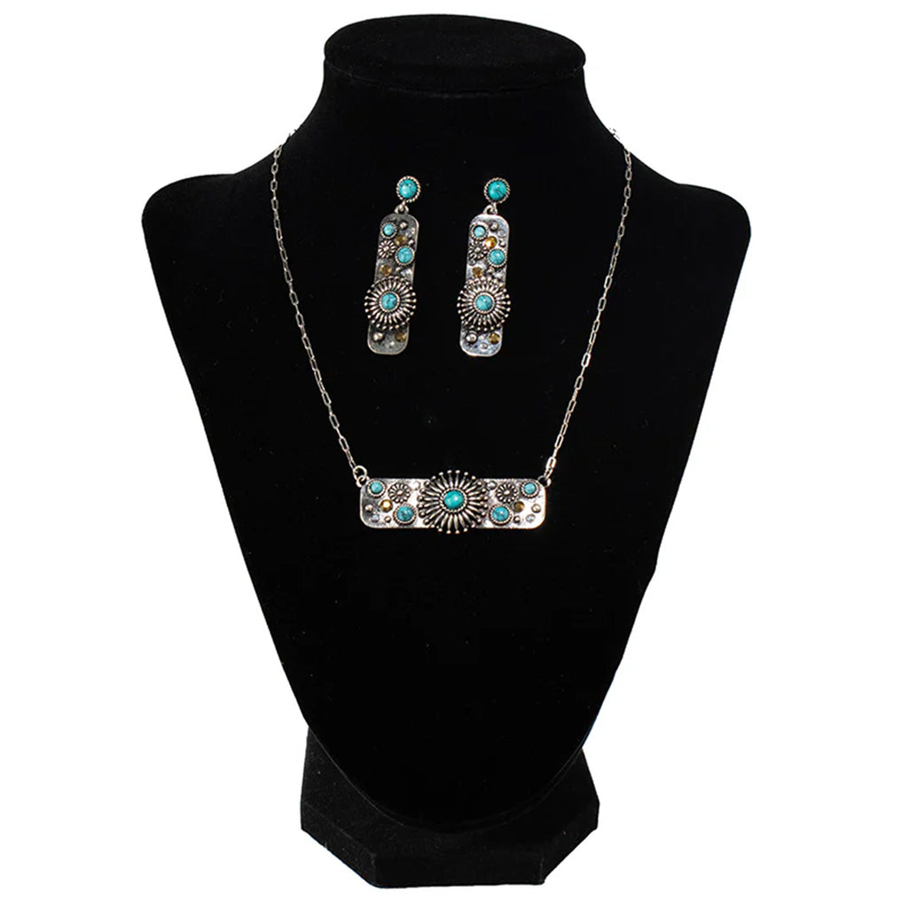 M&F Turquoise Stone & Flower Bar Earring & Necklace Set sitting on stand. 