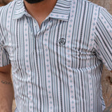 Close up view of the male model wearing the white and blue striped polo. 
