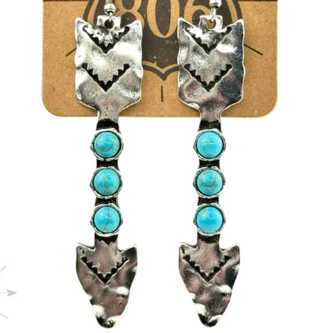 Long arrow earrings with three turquoise stones in the middle of the shaft.