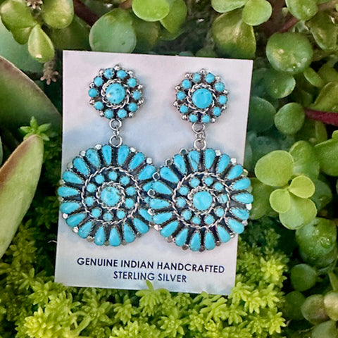 Turquoise Cluster earrings on a card with green foliage background