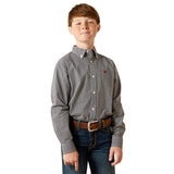Young boy wearing a patterned shirt and jeans on a white background