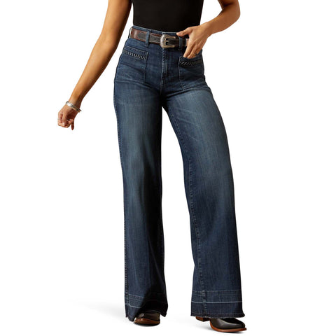 Front view of person wearing dark wash wide leg jeans with square pockets on a white background.