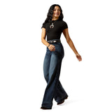 Woman turning wearing a black shirt and high rise wide leg jeans on a white background.