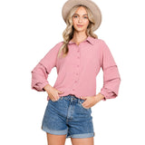 Woman wearing a solid mauve shirt with tiered ruffle long sleeves