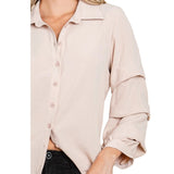Close up of a tan blouse with tiered ruffled sleeves