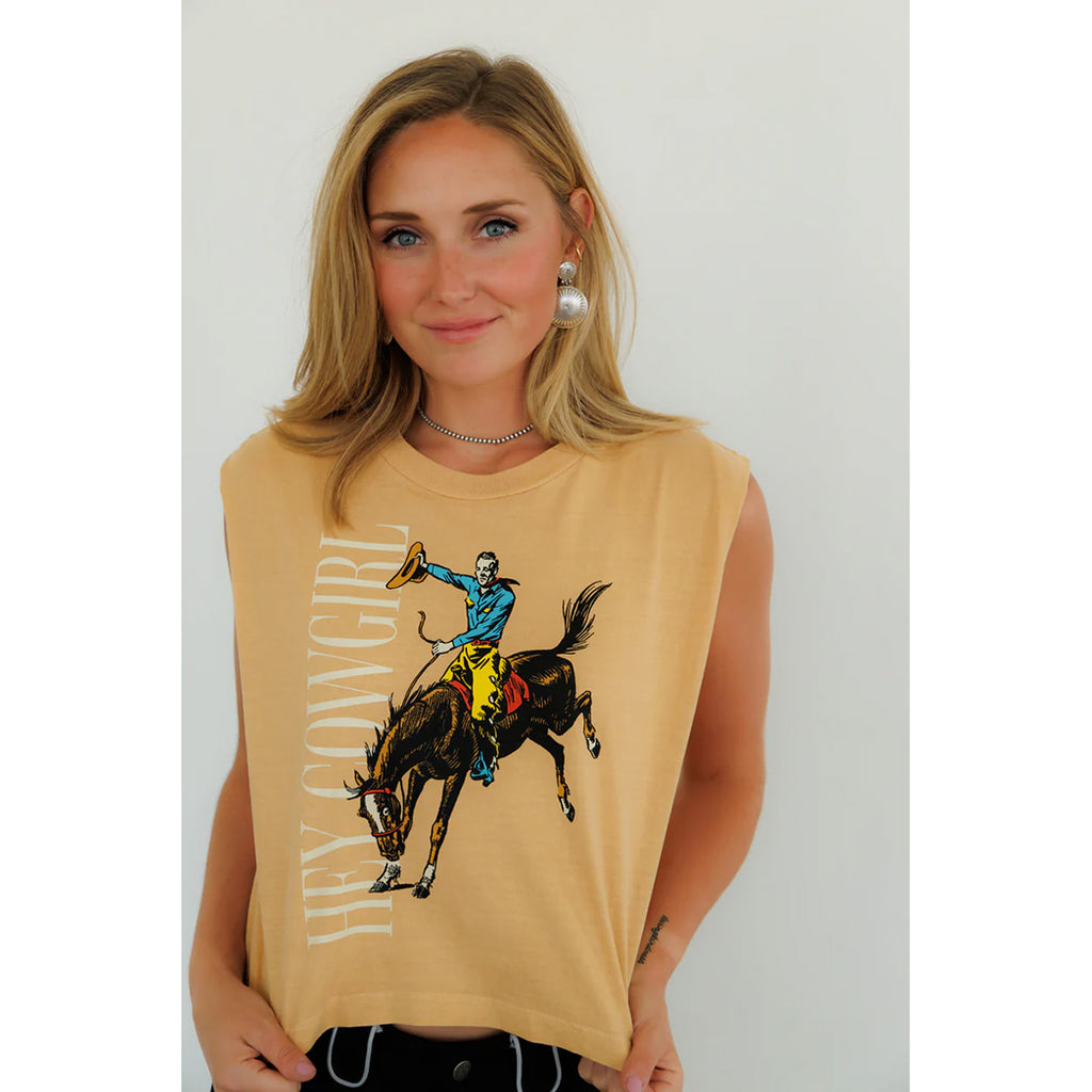 Model wearing the sleeveless ‘Hey Cowgirl’ bronco graphic top, front view showing the bold Western bucking bronco design, relaxed slightly cropped fit, and raw‑edge armholes.