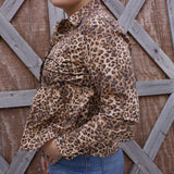 Side view of the blouse, sleeves have three black pearl snaps.
