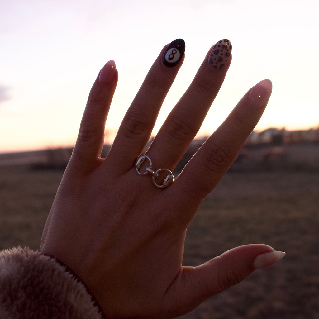 Silver ring with a horse bit design.
