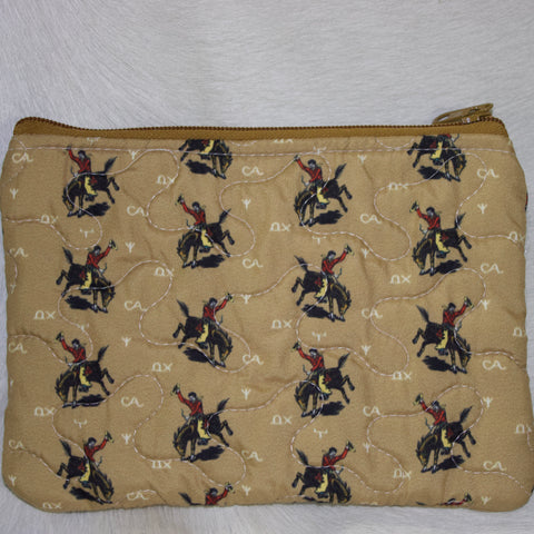 Tan quilted makeup bag with white branded detailing and retro cowboy bronc design. 