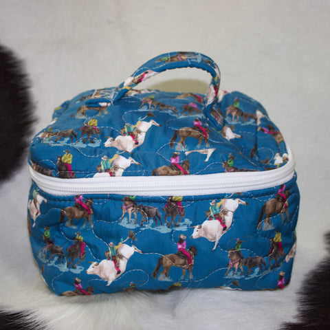 Dark blue quilted travel case with rodeo designs all over and a white zipper that goes around three sides and a handle on top.