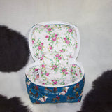 View inside of the travel case, no dividers and inside fabric is white with pink and yellow flowers. 