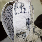 Back view of the bag, long vertical zipper and black and white floral fabric inside the bag.
