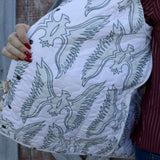 Inside lining of the coat, Fabric is white with a light green thunderbird pattern.