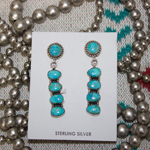 Sterling silver and Kingman turquoise earrings with small circle stone on the top and a four stone drop bar underneath.