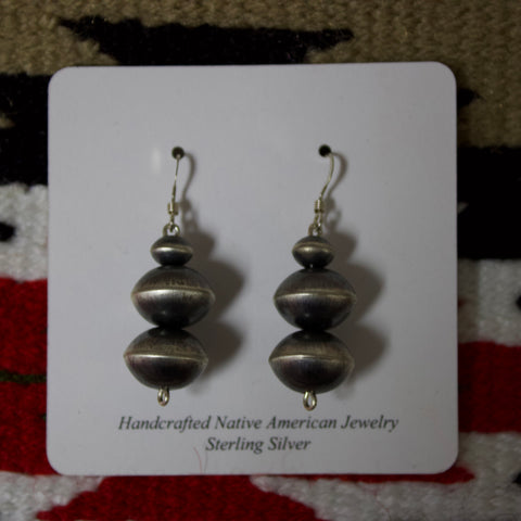 Navajo pearl earrings with three large Navajo pearls stacked on top of each other.