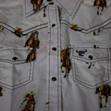 Close up view of the shirt, it has black pearl snap buttons and black stitching.