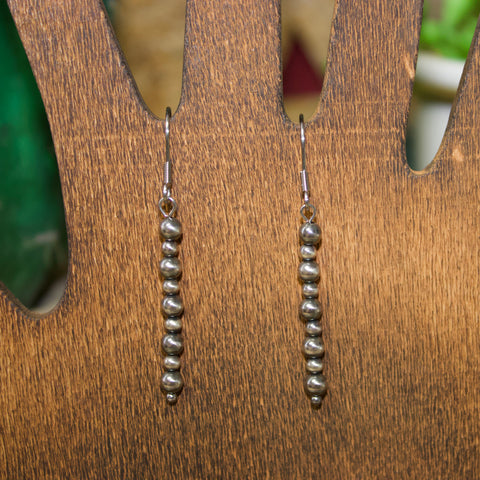 Straight string of nine small Navajo pearl earrings.