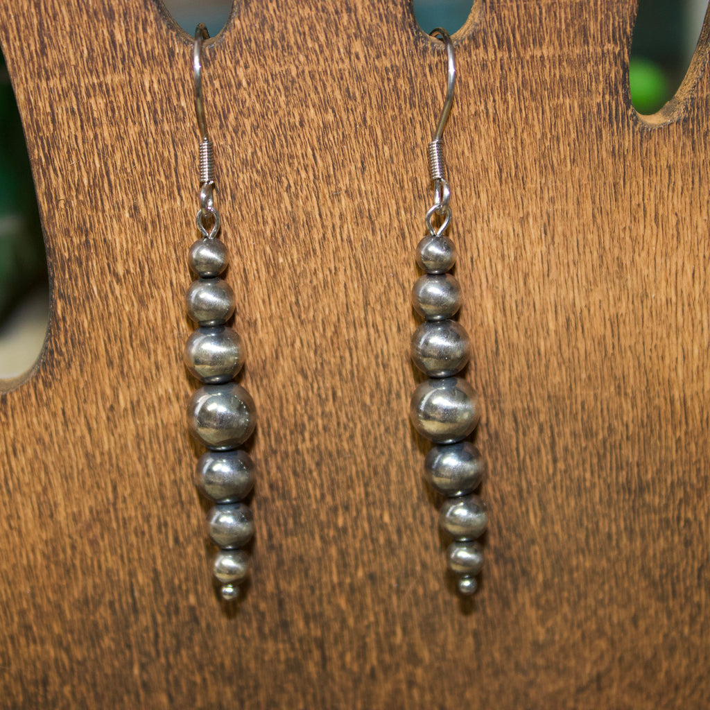 Long straight string of graduated Navajo style pearl earrings.