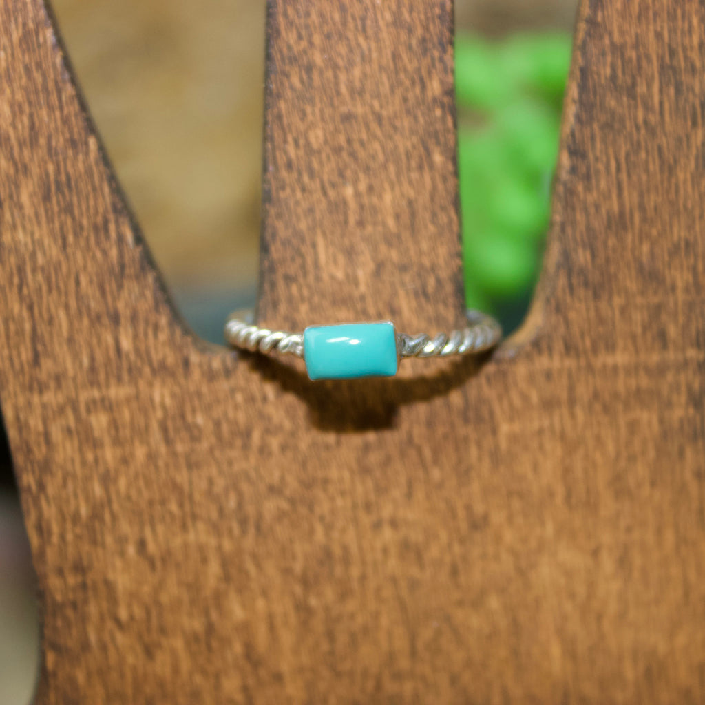 Small silver ring with a twisted rope band and a small rectangular turquoise stone.