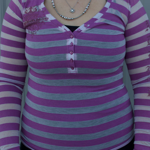 White and Purple Horizontal stripe long sleeve shirt with purple button that go half way down the front of the shirt and rhinestone designs on the shoulder and sleeve.