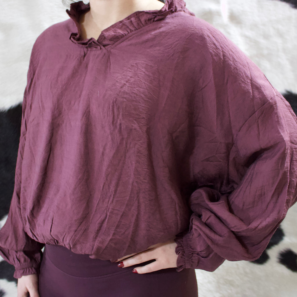 Merlot colored puffy long sleeve shirt with a ruffles collar and ruffled cuffs. 