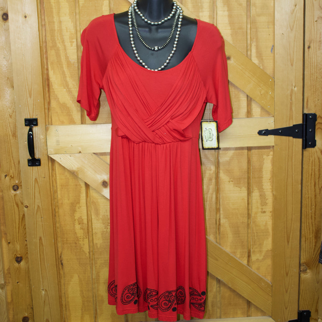 Red above the knee length dress that has short sleeves, crossed baggy fabric on the chest, and black bandana stitching along the bottom. 