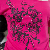 Close up view of the shirt print. Heart has "COWGIRL TUFF" written on it and print is accompanied by rhinestones. 