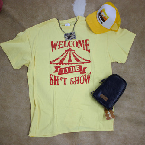 Flat lay view of yellow and red t shirt with hat, necklace, and purse sitting next to it. 
